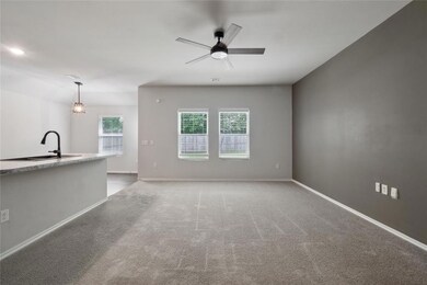Unfurnished living room featuring sink, carpet flo