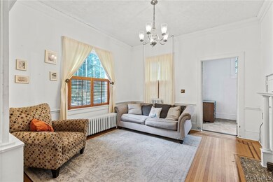 Living room with wood-type flooring, a chandelier,