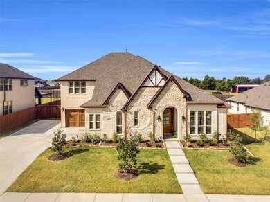 View of front facade featuring  driveway, stone siding, and brick siding