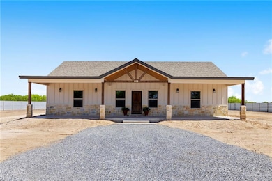 Modern inspired farmhouse featuring board and batten siding, stone siding, and roof with shingles