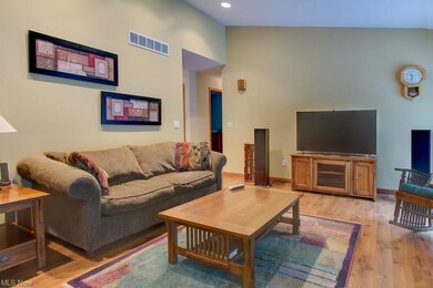 The spacious family room has a vaulted ceiling, re