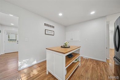 Island features storage shelving while the wall pantry adds charm and storage.
