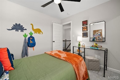 Carpeted bedroom with a ceiling fan and baseboards