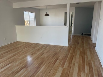 Empty room with light wood-style floors and baseb