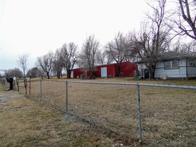 View of yard with fence and red garage shop