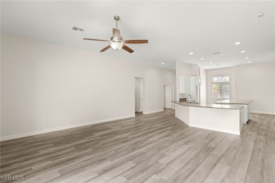 Great room with a ceiling fan and high ceilings