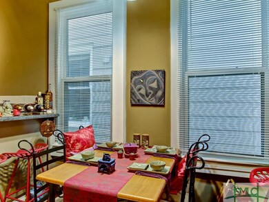 Apartment A: dining area with tall windows and bre