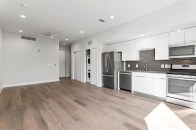 Kitchen featuring white cabinetry, appliances wit