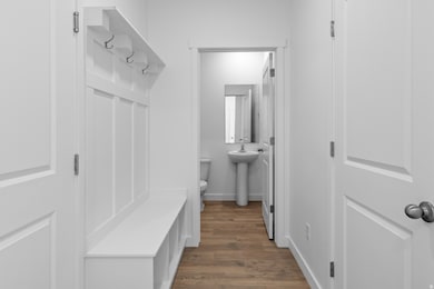 Mudroom featuring dark wood-style floors and baseboards
