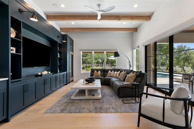 Living room with light wood-style flooring, beamed ceiling, and recessed lighting