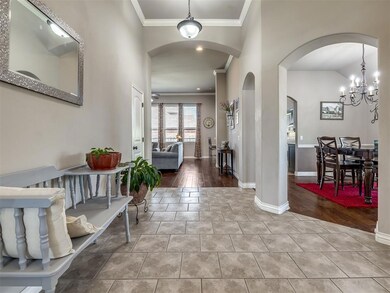 Entryway with crown molding, tile patterned floors