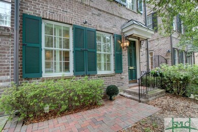 Brick sidewalk leads to front door.  Townhouse is 
