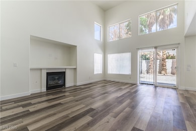 Unfurnished living room with a high ceiling, a gla