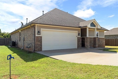 View of home's exterior with an attached garage, brick siding, driveway, and roof with shingles