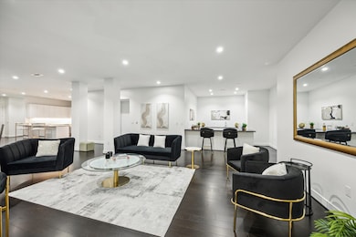 The family room could easily be set up to have multiple sitting areas and a game table. The two white columns in the back of the picture between the two back couches frame the entry into the residence from the direct access elevator.