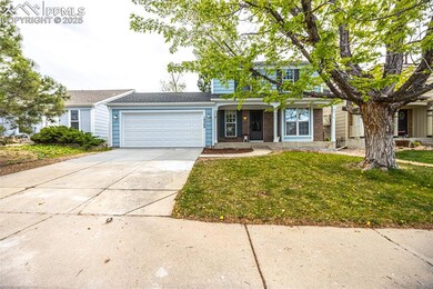 View of front of house featuring a garage, concrete driveway, a front yard, and brick siding