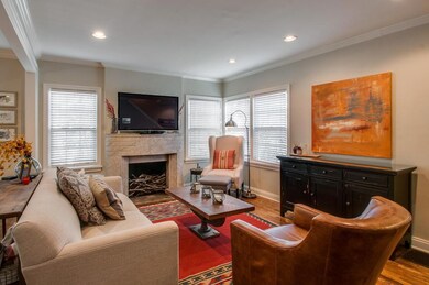 Living room with beautiful hardwoods, big windows & fireplace.