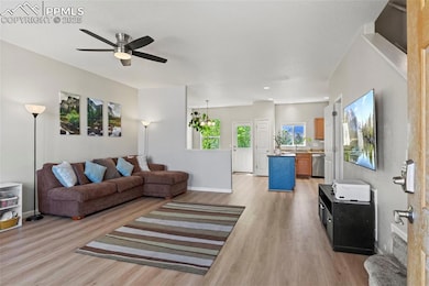 Living room with baseboards, a ceiling fan, and li