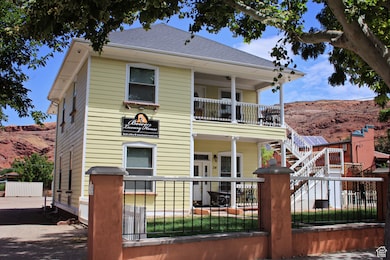 View of front facade featuring a fenced front yard, a balcony, a mountain view, and a gate