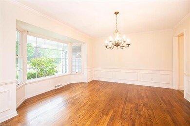 Spare room with light hardwood flooring, a chandel