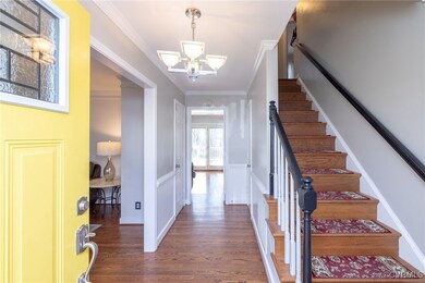 Entryway with stairs, wood finished floors, a chan