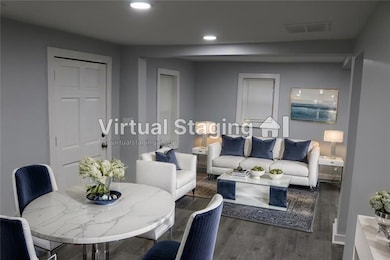 Living room featuring wood finished floors, visible vents, and recessed lighting