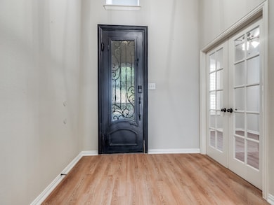 Entrance foyer featuring light wood-style floors and french doors