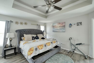 Bedroom with crown molding, wood finished floors,