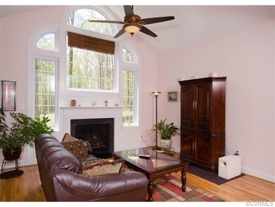 The great room has a dramatic vaulted ceiling, three Palladian windows surrounding a gas fireplace, ceiling fan and hardwood floor. The windows overlook the private, waterfront property!