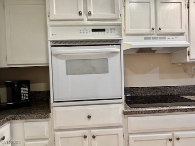 Kitchen featuring under cabinet range hood, black