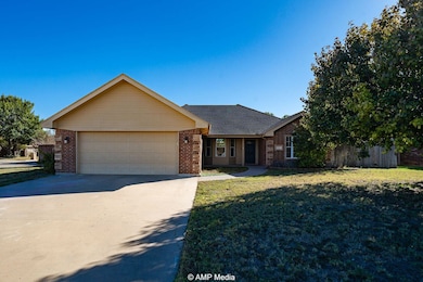 Ranch-style home featuring concrete driveway, brick siding, a garage, and roof with shingles