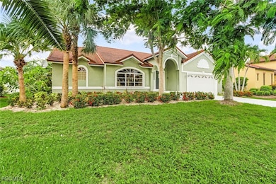 View of front facade with stucco siding, driveway, a front yard, an attached garage, and a tiled roof