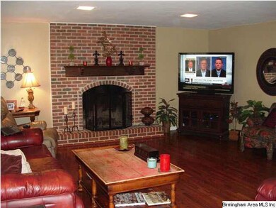 Large family room with hardwood floors & brick fir