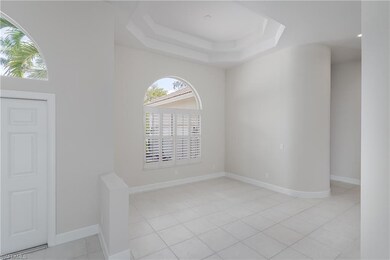 Tiled empty room featuring a raised ceiling