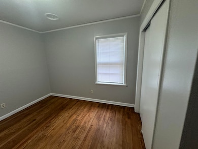 Unfurnished room with ornamental molding and dark hardwood / wood-style floors