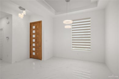 Unfurnished room featuring a chandelier, marble look tiles, and baseboards