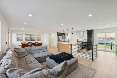 Living area with light wood-style floors and recessed lighting