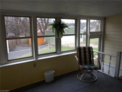 Enclosed 3 season porch overlooks fenced backyard.