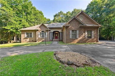 View of front of property featuring brick siding, driveway, and crawl space