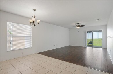 Breakfast room/family room with new wide planked laminate flooring, new blinds, lighting and ceiling fan. Leads out to the covered lanai through sliding door..