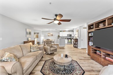 Living room with ceiling fan and light wood-type f