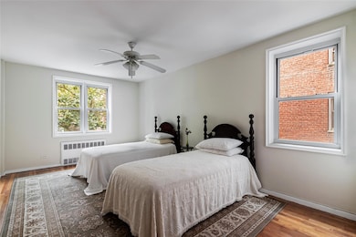 Bedroom with radiator, hardwood / wood-style flooring, and ceiling fan