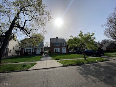 View of front facade featuring a front yard, brick siding, and a residential view