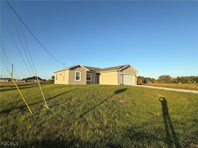 Ranch-style house featuring a front lawn, a garage, and driveway