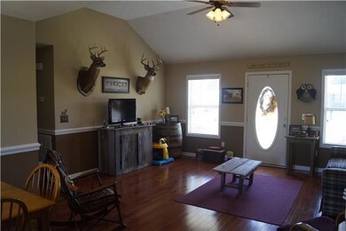 Living room with hardwood floors, vaulted ceiling.