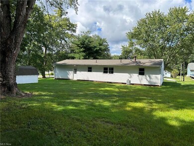 Rear view of property featuring a yard and an outd