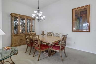 Carpeted dining area featuring a chandelier