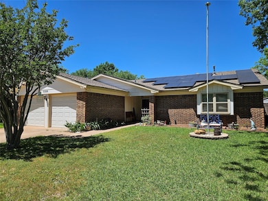 Ranch-style home with solar panels, a garage, and 