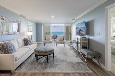 Living area featuring ornamental molding, wood finished floors, baseboards, and healthy amount of natural light