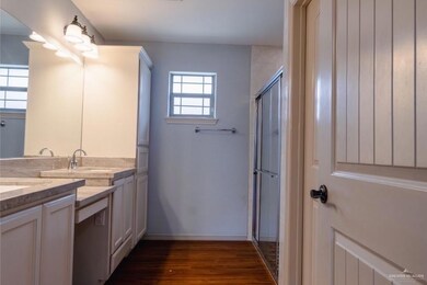 Bathroom featuring plenty of natural light, vanity, a shower with shower door, and hardwood / wood-style flooring